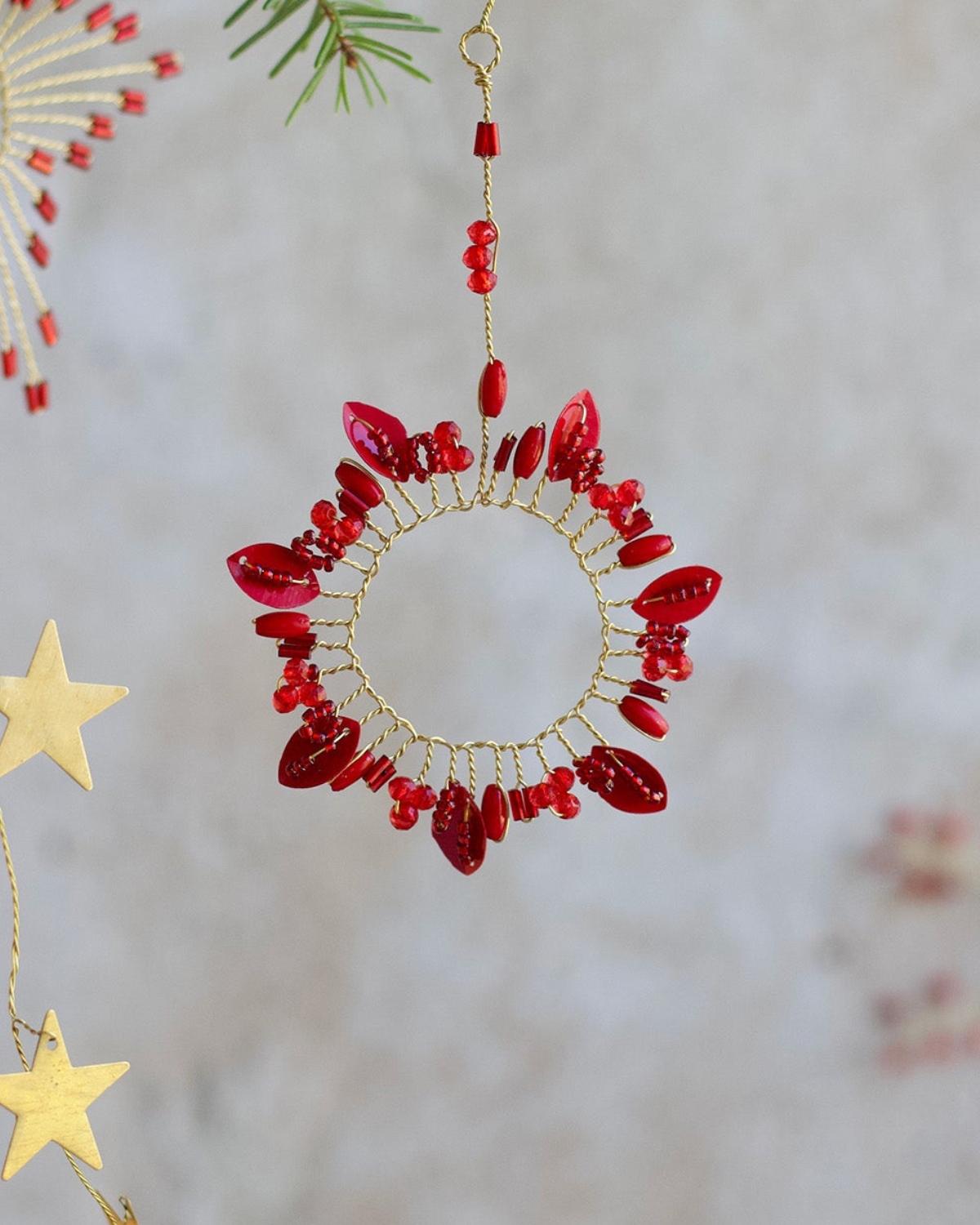 Close-up van handgemaakt rode kransornament met glanzende dieprode kralen, uniek en feestelijk kerstdecoratie-accessoire