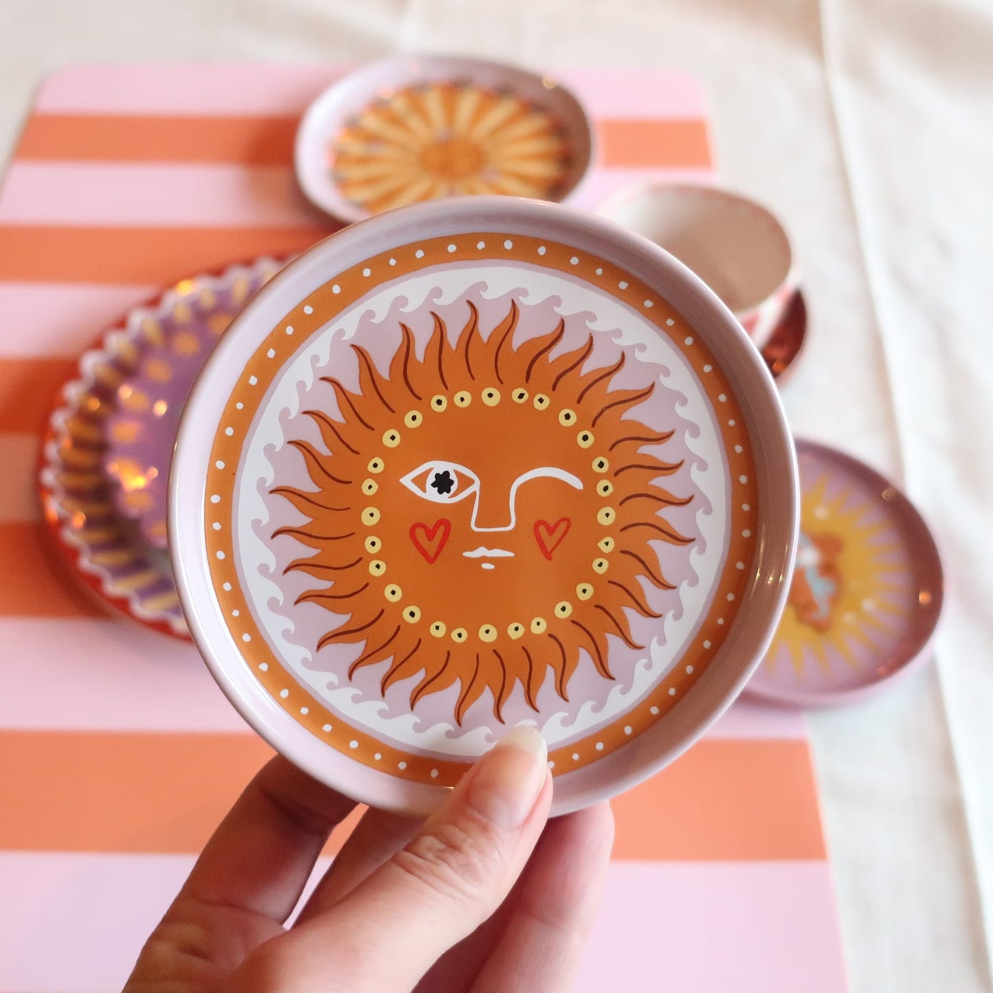 Close-up van het handgemaakte kleine bordje met vrolijk zonnetje. Perfect voor ontbijt, lunch of een gezellig diner. Duurzaam en vaatwasserbestendig.