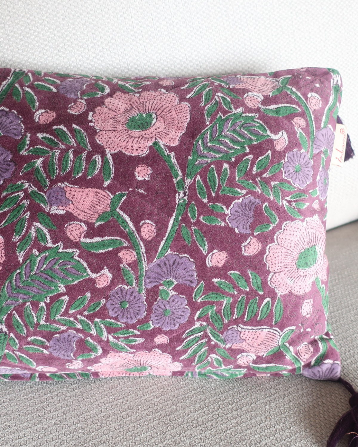 Close-up van de kwastjes en doorgestikt ruitpatroon op het velvet kussen Eleana