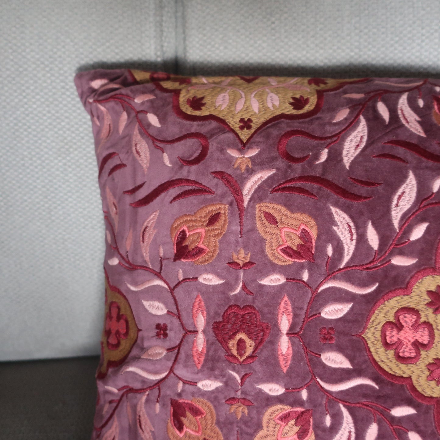 Close-up van het geborduurde bloemendesign op handgemaakt velvet kussen Violette van Imbarro.