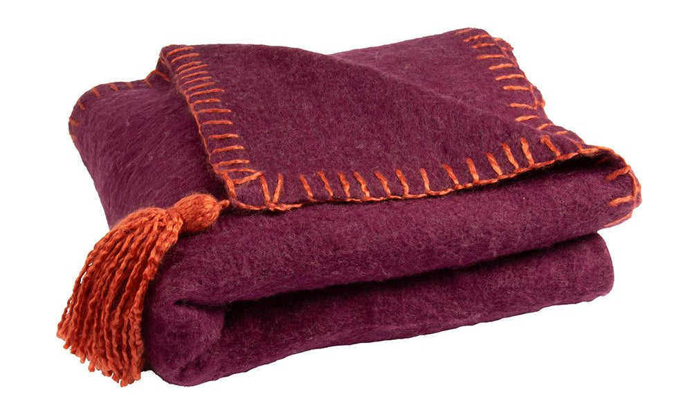 Zacht en warm plaid Evie Darkred van Imbarro in rood en paars met kwastjes, handgemaakt woonaccessoire voor een cosy en stijlvol interieur.